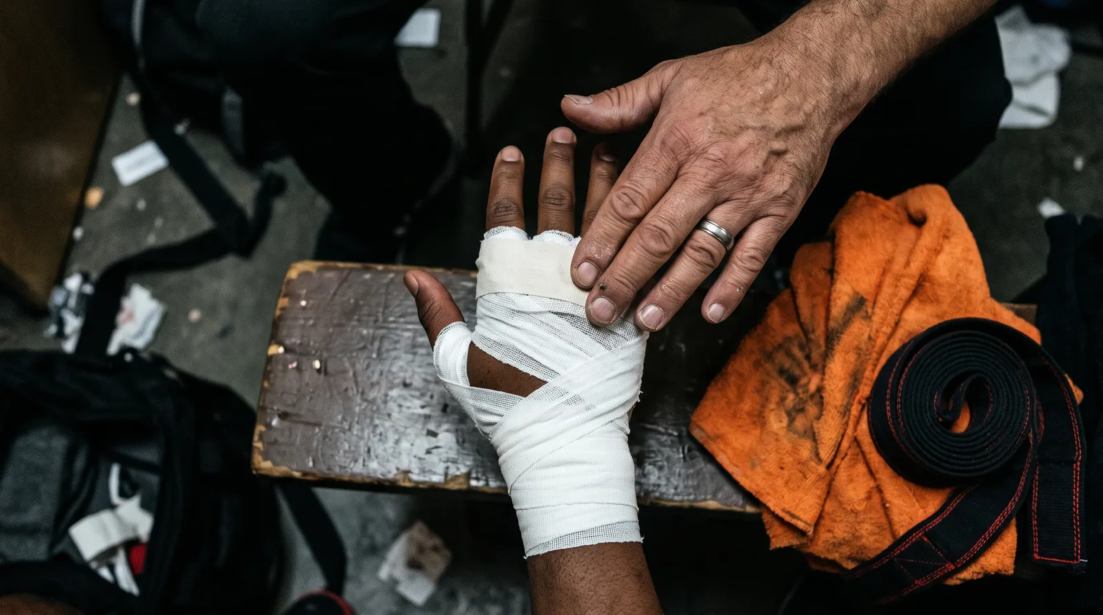 Close-up of a fighter's hands being taped in a locker room before a bout